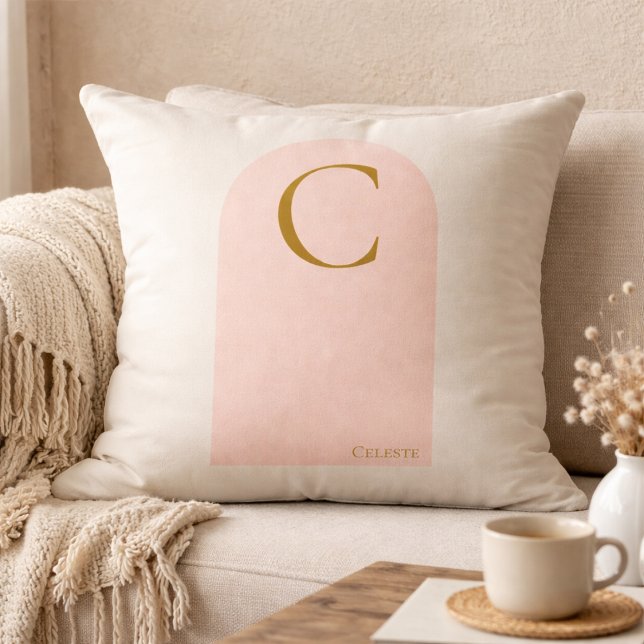 Oreiller jeté au monogramme en arche rose (Soft ivory meets blush arch detail, finished with a gold serif monogram for refined neutral living.)