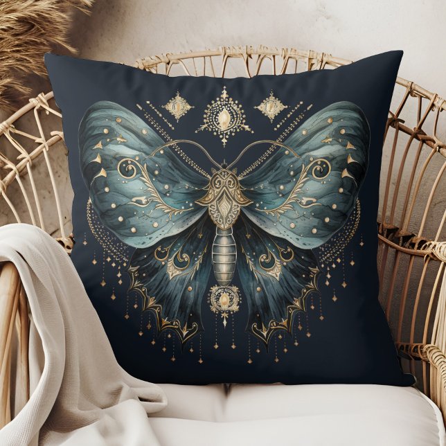 Oreiller jeté de sorcière de papillon de nuit bleu (Celestial Blue Moth Witchmas Throw Pillow in a boho rattan armchair.)