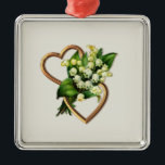 Ornement Carré Argenté Two Romantic Hearts with White Lilies<br><div class="desc">This ornament has two gold entwined hearts with a lily of the valley spray. The open hearts are horizontal with the spray of flowers going through the center. You can add text and change the background color with the personalize option. You will find other items with this motif in the...</div>