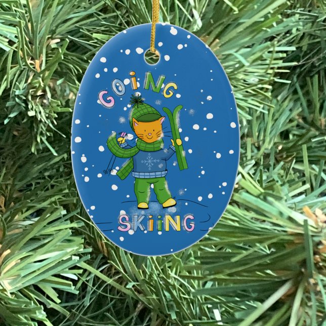Ornement de Noël de chat faisant du ski (Cat going skiing blue oval ceramic Christmas ornament .)