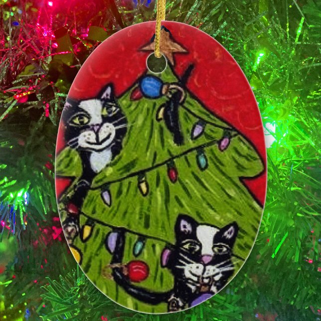 Ornement En Céramique Art populaire Chats Arbre de Noël (Naughty cats climbing in Christmas tree with gold star and lights on oval Christmas ornament.)