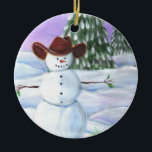Ornement En Céramique Cowboy Snowman<br><div class="desc">Cowboy Snowman a illustré la photo. Il porte un casquette de cowboy brun,  s'assied dans des rouleaux de neige avec des pins et le coucher de soleil violet dans l'arrière - plan.</div>