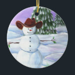 Ornement En Céramique Cowboy Snowman<br><div class="desc">Cowboy Snowman a illustré la photo. Il porte un casquette de cowboy brun, s'assied dans des rouleaux de neige avec des pins et le coucher de soleil violet dans l'arrière - plan.</div>