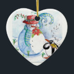 ORNEMENT EN CÉRAMIQUE LA SÉRÉNADE HIVERNALE DE SNOWMAN ET PENGUIN<br><div class="desc">Peinture originale couleur pastel en bleu blanc,  bonhomme de neige et pingouin jouant du violon dans la neige hivernale avec des fleurs rouges,  fleurit.par Bulgan Lumini (c)</div>