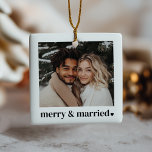 Ornement En Céramique Merry & Married Heart Photo<br><div class="desc">This holiday ornament is designed for newlyweds celebrating their first married Christmas, blending modern simplicity with seasonal charm. It features a photo that you can upload to showcase your favorite moment together. The phrase "merry & married" in a bold typographical design is accompanied by a delicate heart next to it....</div>