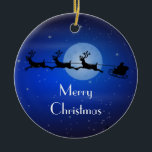 Ornement En Céramique Père Noël de Noël personnalisée<br><div class="desc">Personnalisez avec votre propre texte. Illustration de noël festif. Père Noël dans son traîneau et son renne volant à travers le ciel bleu foncé. Une lune éclatante illumine le ciel et on peut voir des étoiles scintillantes tout autour.</div>