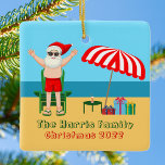 Ornement En Céramique Sunny Beach Santa Claus Cute Custom Christmas<br><div class="desc">Ce joli décor de Noël personnalisé en juillet rend parfait décor de fête d'été pour un bain de plage ou un rassemblement de piscine. Faites-en une extravagance amusante sur le thème du pôle nord avec le Père Noël dans ses maillots de bain à côté d'un parapluie de plage rayé rouge...</div>
