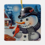 Ornement En Céramique Winter Snowman & Red Cardinal Bird Aquarelle Art<br><div class="desc">"Feathered Friend" Aquarelle Art céramique Ornament de l'artiste Jean Weiner "Feathered Friend" présente un oiseau cardinal du Nord mâle perché sur la mitaine d'un bonhomme de neige. L'oiseau et le bonhomme de neige semblent échanger un accueil amical entre eux. Le bonhomme de neige porte un casquette derby noir et un...</div>