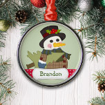 Ornement En Métal Joli Enfants Snowman personnalisé<br><div class="desc">Un mignon bonhomme de neige habillé en chapeau et manteau en plaid porte un arbre de Noël. En bas se trouve une bande de pois rouge et blanc avec une bannière blanche portant le nom de votre enfant ou tout autre texte personnalisé. L'image et la bannière sont placées sur un...</div>
