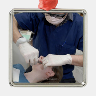 Ornement En Métal Orthodontiste rajustant les croisillons dentaires