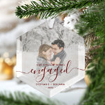 Ornement En Verre Script rouge photo personnalisé de Noël<br><div class="desc">Commémorez votre fiançailles avec ce magnifique ornement de gardien moderne. Le texte rouge foncé dit "Notre premier Noël engagé", avec le mot "engagé" dans un élégant script d'écriture manuscrite avec des fioritures avant et après. Remplacez l'exemple d'image par votre photo préférée, et ajoutez vos noms et l'année. Un filtre dégradé...</div>