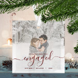 Ornement En Verre Script rouge photo personnalisé de Noël<br><div class="desc">Commémorez votre fiançailles avec ce magnifique ornement de gardien moderne. Le texte rouge foncé dit "Notre premier Noël engagé", avec le mot "engagé" dans un élégant script d'écriture manuscrite avec des fioritures avant et après. Remplacez l'exemple d'image par votre photo préférée, et ajoutez vos noms et l'année. Un filtre dégradé...</div>