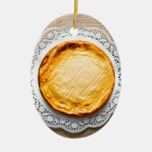 Ornement Ovale En Céramique Cheesecake on rustic wood cake top.