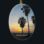 Ornement Ovale En Céramique Venice Beach California Sunset Souvenir<br><div class="desc">Cette image photographique montre de grands palmiers en silhouette debout contre un magnifique coucher de soleil jaune, doré, orange et rouge sur l'océan Pacifique à Venice Beach, Californie. Ajoutez du texte en option ou vos dates de vacances pour un souvenir unique. Autre design exclusif original par Sonja Quidama Image Code...</div>