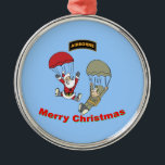 Ornement Rond Argenté Père Noël aéroporté II<br><div class="desc">Depuis que Père Noël a gagné ses ailes aéroportées,  il aime parachuter avec ses copains militaires. Cette année,  il livrera certainement des cadeaux de Noël en parachute</div>