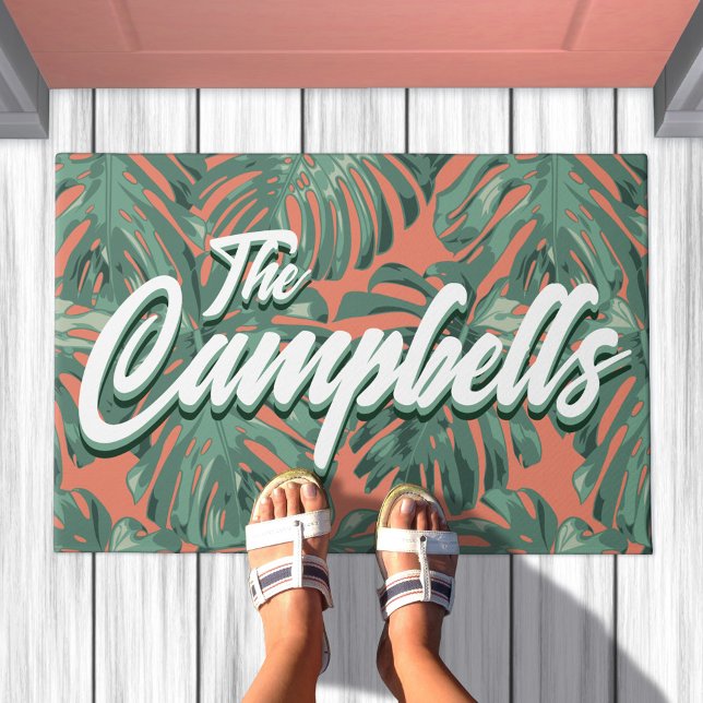 Paillasson Feuilles tropicaux Script vert Nom de famille mat  (Doormat with green leaves on orange background. Text overlay says your family name)