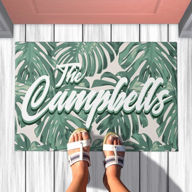 Paillasson Green Tropical Feuilles Script Nom mat Doormat (Doormat with pattern of sage green tropical leaves. Overlaid is your family last name)