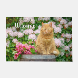 Paillasson Un chat orange dans un jardin aux fleurs de printe