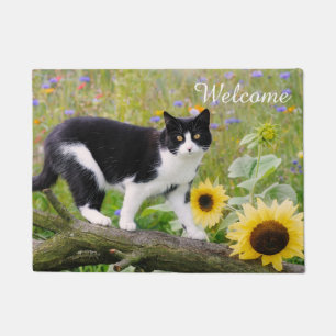 Paillasson Un mignon chat tuxedo sur une branche d'arbre avec