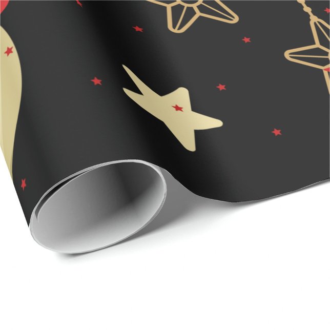 Papier Cadeau Ornements de vacances (A roll of wrapping paper with a black background and a pattern of gold stars and red stars. )