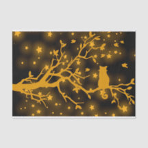 Chat étoilé de nuit sur une branche d'arbre