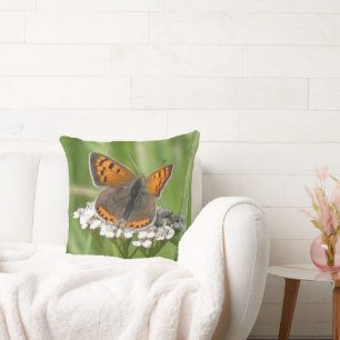 Petit coussin jeté en cuivre sur fleurs blanches