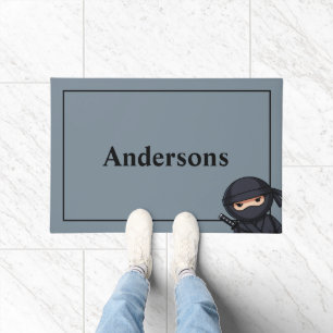 Petit guerrier ninja sur tapis de porte gris