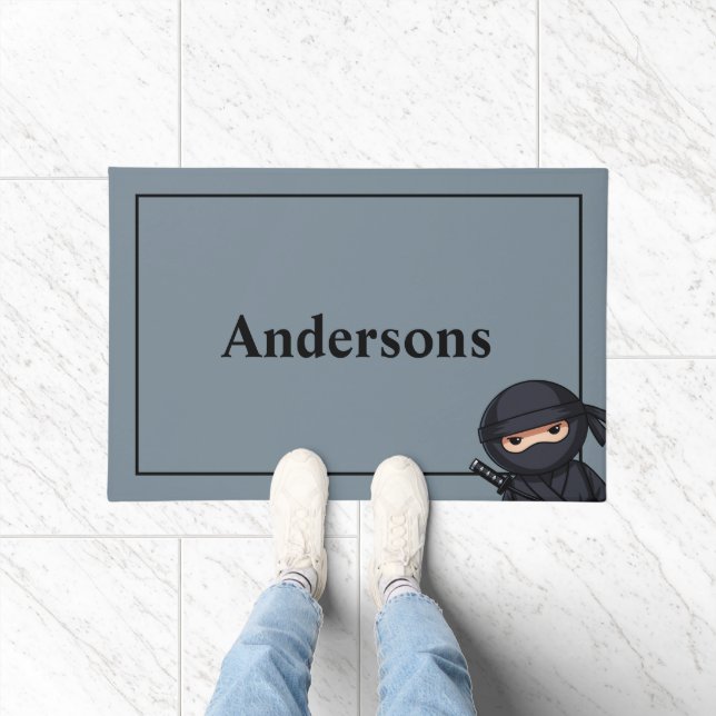 Petit guerrier ninja sur tapis de porte gris (Intérieur)