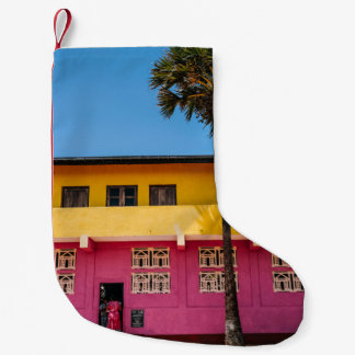 PETITE CHAUSSETTE DE NOËL BÂTIMENT EN BÉTON ROUGE ET BROWN PRÈS DE L'ARBRE S