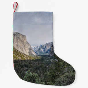 PETITE CHAUSSETTE DE NOËL DES ARBRES VERTS PRÈS DE LA MONTAGNE SOUS LE CIEL