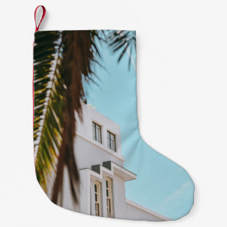 Petite Chaussette De Noël Palmier près d'un bâtiment en béton blanc