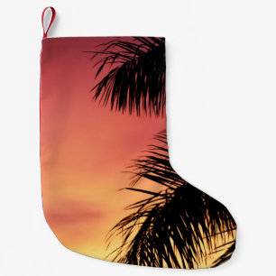 PETITE CHAUSSETTE DE NOËL PALMIER SOUS LE CIEL NUAGE PENDANT LE COUCHER DE S