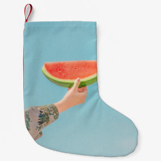 Petite Chaussette De Noël Personne tenant de la pastèque tranchée