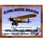 Photo Sculpture Symbole de l'aviation vintage de l'orignal<br><div class="desc">Un panneau patiné annonçant les services de la mythique Flying Moose Aviation de Talkeetna, Alaska. Il est équipé d'un des avions bleu et jaune de la société, équipé de pneus "toundra" très gros pour atterrir sur un terrain accidenté. Lecture de texte, "VOL AVIATION MOOSE", "Nous volons, dites-nous où vous voulez...</div>