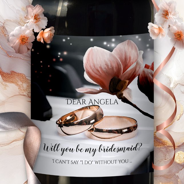 Piano Musique Mariage Anneaux Bridesmaid Étiquette (Romantic wedding wine label featuring rose gold wedding bands on a piano, with a magnolia flower)