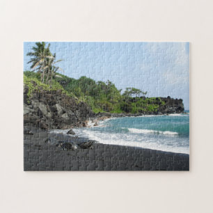 Plage noire de sable sur le puzzle denteux d'Hawaï