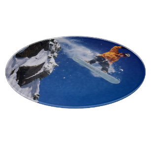 Planche À Découper Un homme en snowboard sautant d'une corniche à