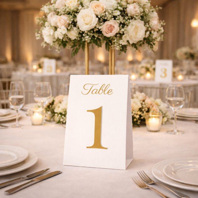 Plaque De Table Numéros de table élégants ivoire et or (Elegant ivory and gold table number displayed at a luxury anniversary reception.)