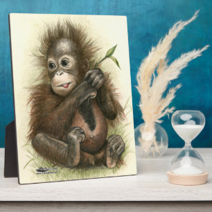 Plaque Photo Bébé orang-outan avec des feuilles