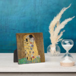 Plaque Photo Le baiser de Gustav Klimt<br><div class="desc">The Kiss by Gustav Klimt The Kiss est une peinture à l'huile sur toile avec de la feuille d'or, de l'argent et du platine. par le peintre symboliste autrichien Gustav Klimt. Il a été peint à un moment donné en 1907 et 1908, au plus fort de ce que les savants...</div>
