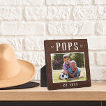 Plaque Photo Polices personnalisées rustiques Grandpa Photo<br><div class="desc">La plaque de grand-père personnalisée pour la Fête des pères, les anniversaires ou la fête des grands-parents présente une photo préférée de son petit-enfant ou de ses petits-enfants avec "Pops" ci-dessus en lettres rustiques. Personnalisez avec l'année où il est devenu grand-père en-dessous, ou ajoutez un message ou un nom personnalisé....</div>