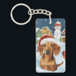 Porte-clefs Dachshund Winter Wonderland Christmas Joy<br><div class="desc">Ce design festif reflète l'esprit joyeux de la période des fêtes, avec un adorable petit portant un chapeau de Père Noël. Le chien est niché dans un pays des merveilles hivernales, avec un bonhomme de neige, un sapin de Noël décoré et des cadeaux joliment emballés. Les flocons de neige tombent...</div>