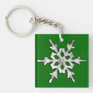 Porte-clefs Flacon de neige blanc et argenté sur le vert de pi