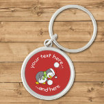 Porte-clés Christmas Penguin Getting a Snow Ball Keychain<br><div class="desc">A little penguin cartoon wearing santa hat and green scarf bending to get a snow ball avoiding another one. Custom background color. Custom text.</div>