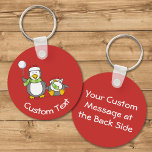 Porte-clés Christmas Snowballing Penguins Keychain<br><div class="desc">A little penguin cartoon with snowball and a fainted one. Both wearing green scarfs and santa hats. Custom background color. Custom text on both sides.</div>