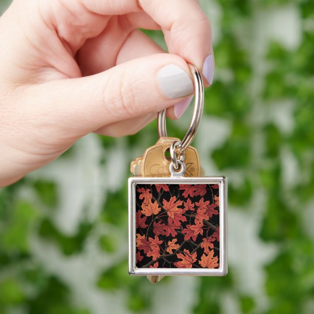Porte-clés Feuilles de l'érable d'automne rouge sur fond noir (main)