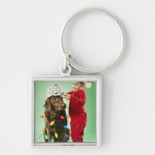 Porte-clés Jeune garçon enroulant des lumières de Noël aut