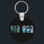 PORTE-CLÉS KIA ORA KIWI ACCUEILLE PAUA<br><div class="desc">Salutation Nouvelle-Zélande classique - dans les couleurs vibrantes de la coquille Paua.</div>