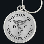 Porte-clés Logo du Docteur en Chiropratique sur Arrière - pla<br><div class="desc">Cette conception présente l'emblème chiropratique et DC au centre,  avec un texte circulaire qui dit "Docteur de Chiropratique" sur un arrière - plan à look métallique argenté.</div>