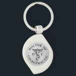 Porte-clés Logo du Docteur en Chiropratique sur Arrière - pla<br><div class="desc">Cette conception présente l'emblème chiropratique et DC au centre,  avec un texte circulaire qui dit "Docteur de Chiropratique" sur un arrière - plan à look métallique argenté.</div>